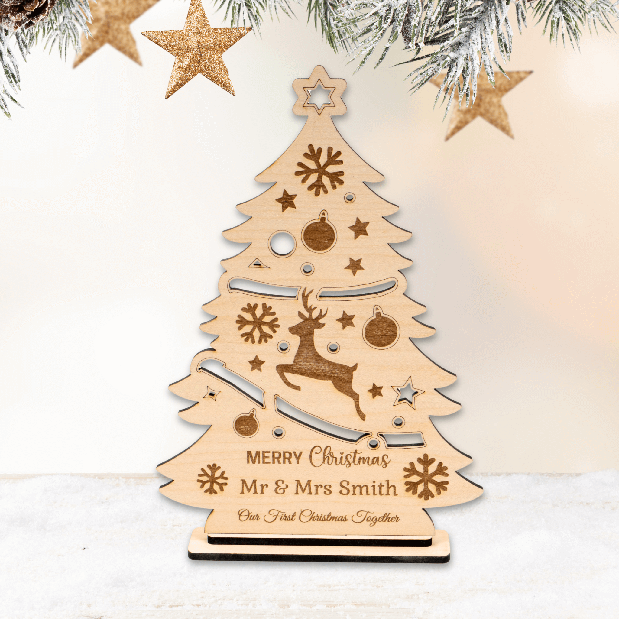 Personalised Christmas tree ornament featuring reindeer, snowflakes, and custom names on a wooden tree design.