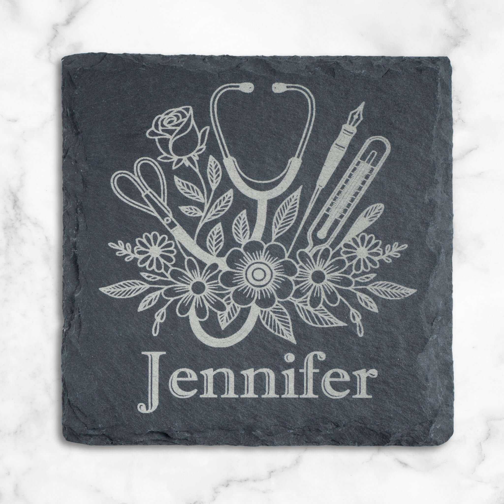 Slate coaster with medical-themed design and name 'Jennifer' on a marble background