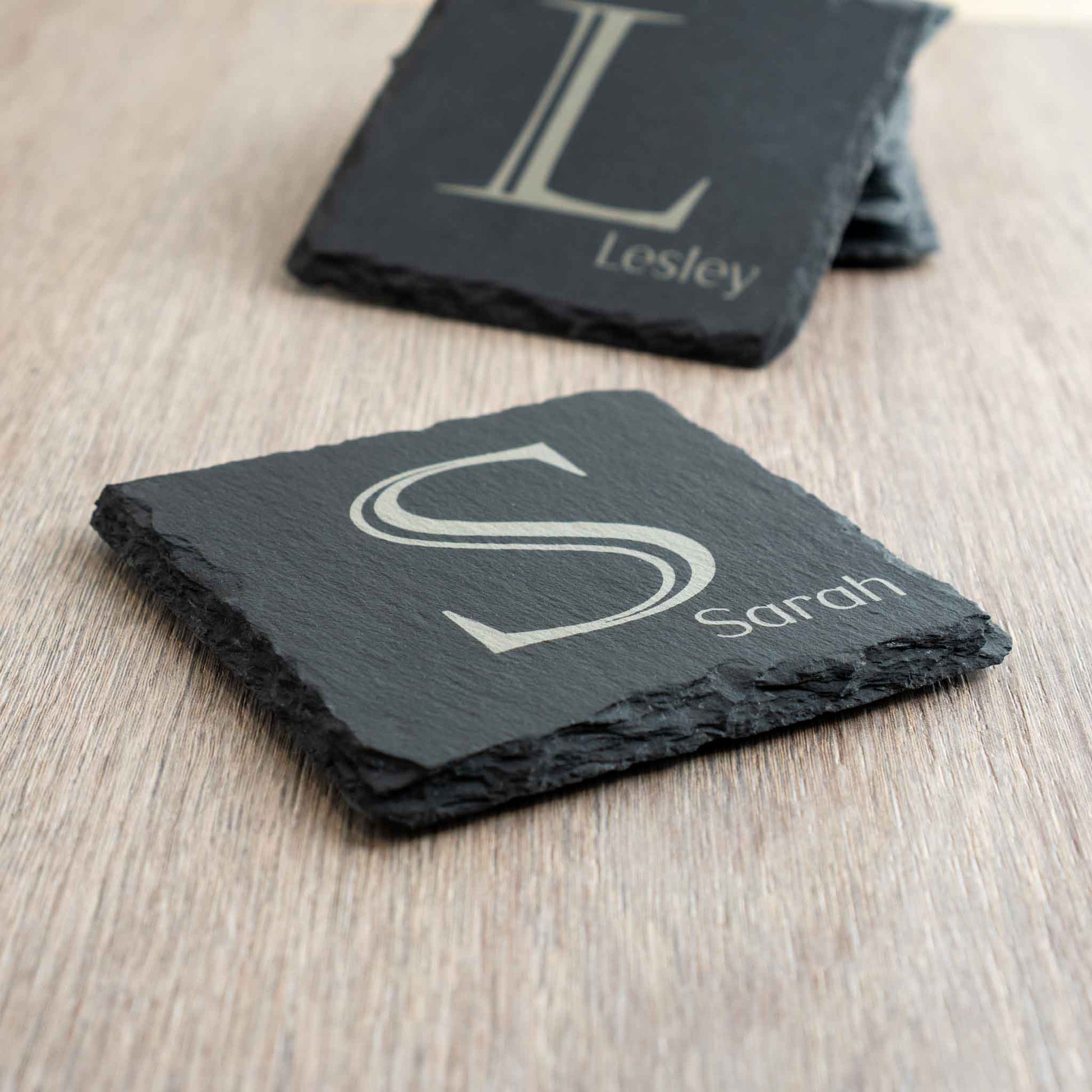 Personalised coaster featuring monogram initial 'S' and name 'Sarah' on a slate surface.