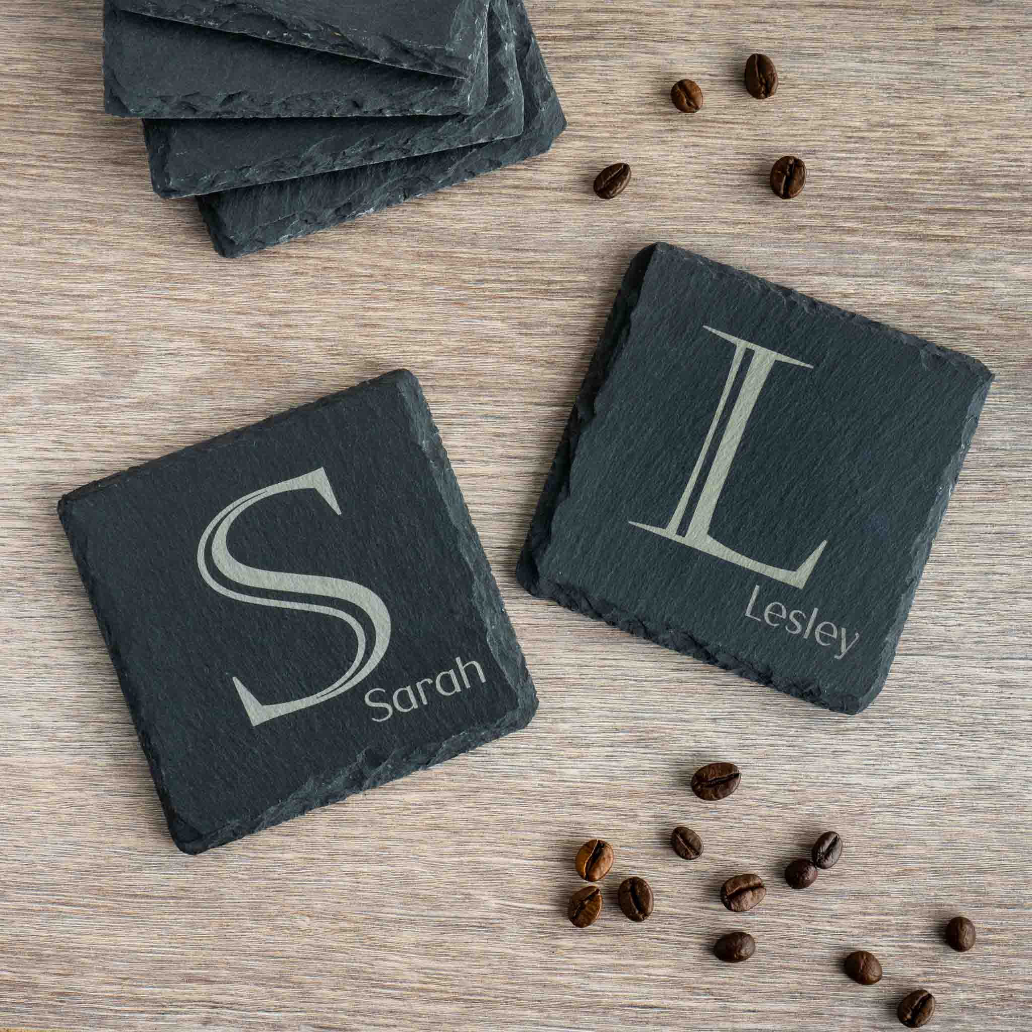Personalised coaster with monogram initials 'S' and 'L' and names 'Sarah' and 'Lesley' displayed on a rustic slate surface.
