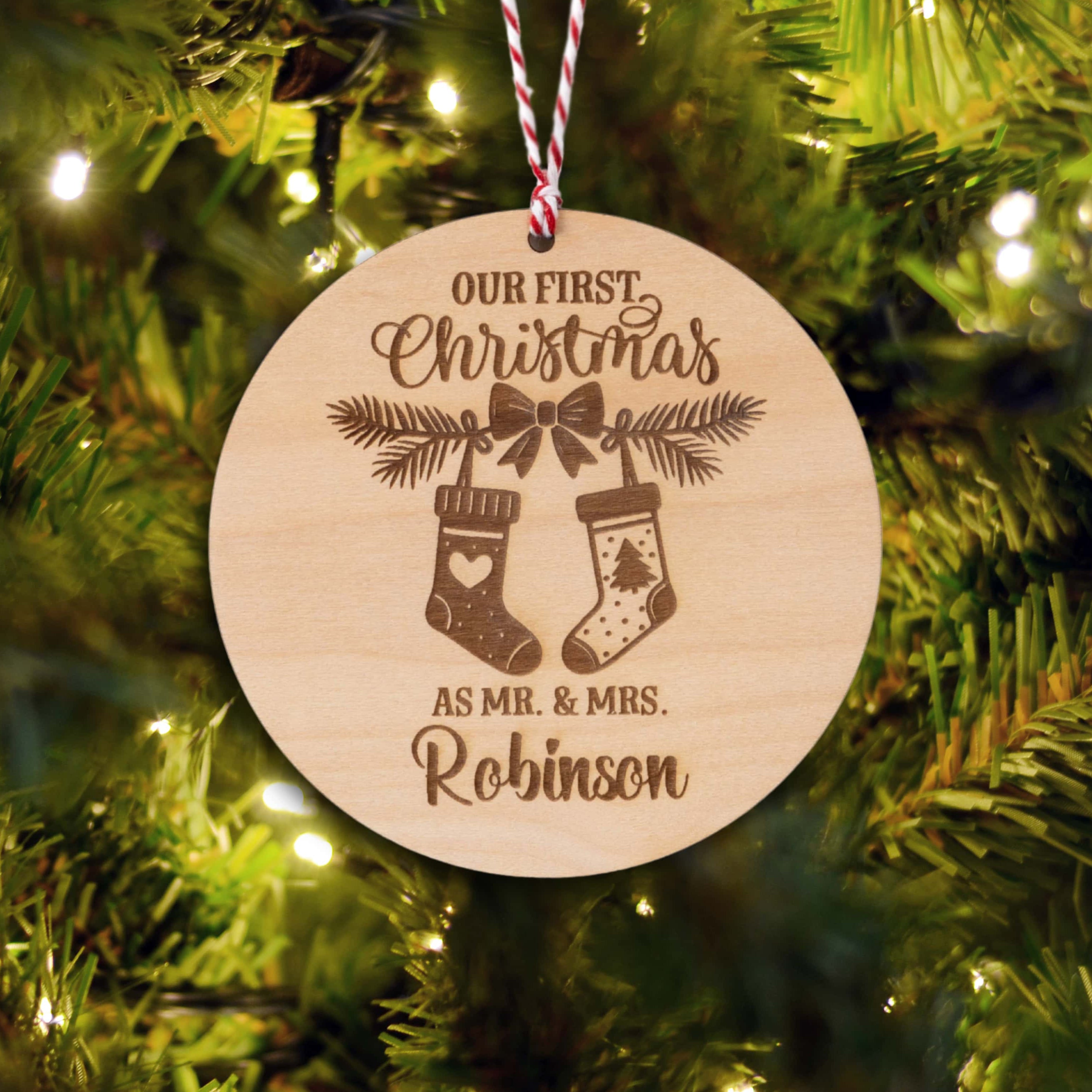 Personalised Couples Christmas Ornament featuring stockings and names on a wooden tree bauble.