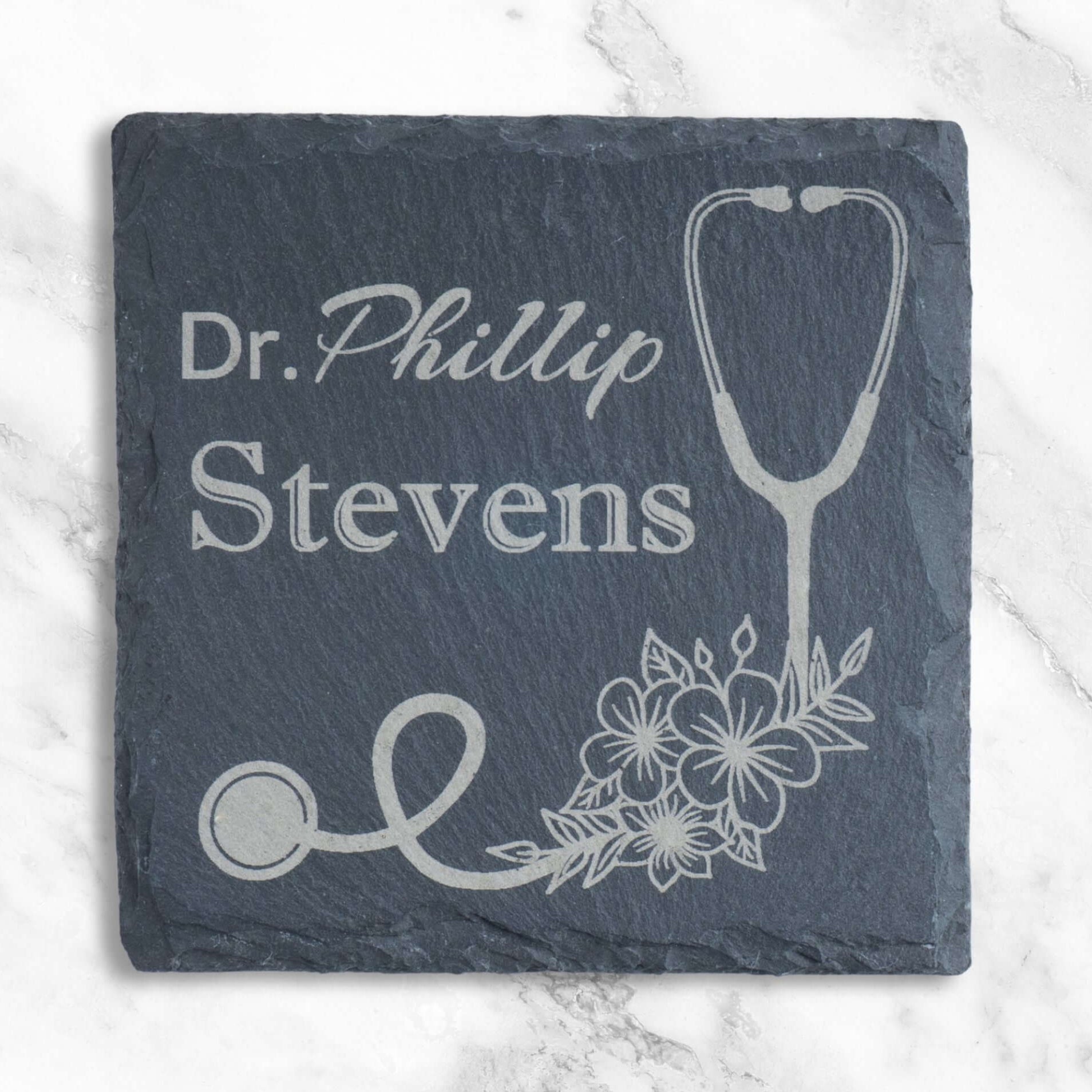 Personalised thank you gift for a doctor: an engraved slate coaster with a custom name and an elegant stethoscope and floral design.